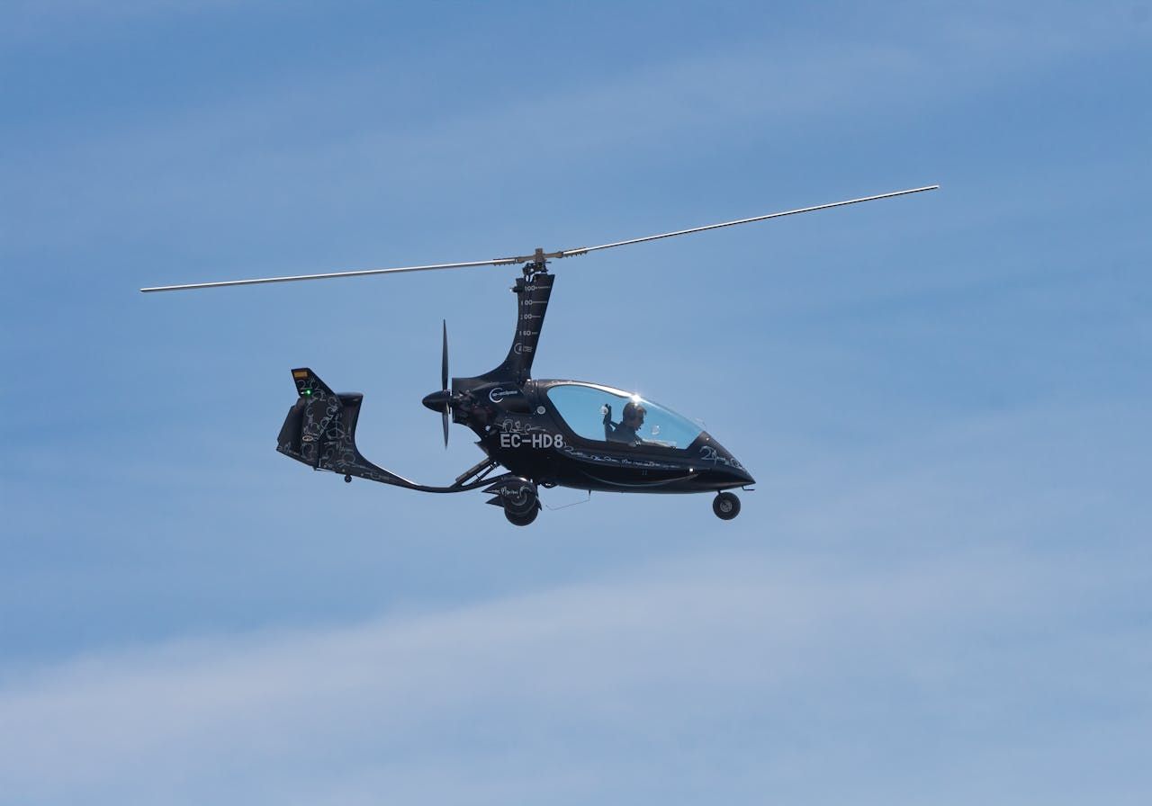 Gyrocopter in flight against a clear sky in San Javier, Spain.